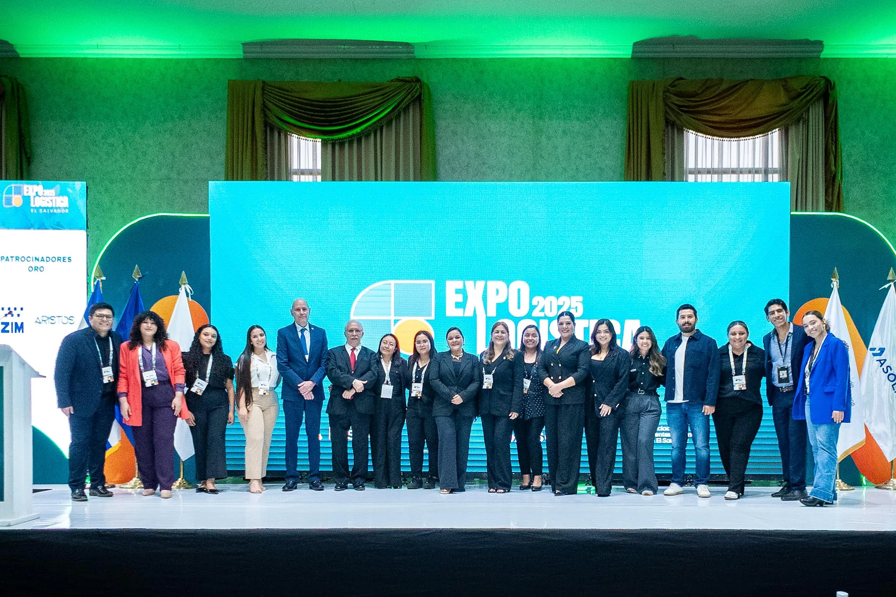 Equipo y participantes frente al escenario principal de Expo Logística El Salvador 2025.